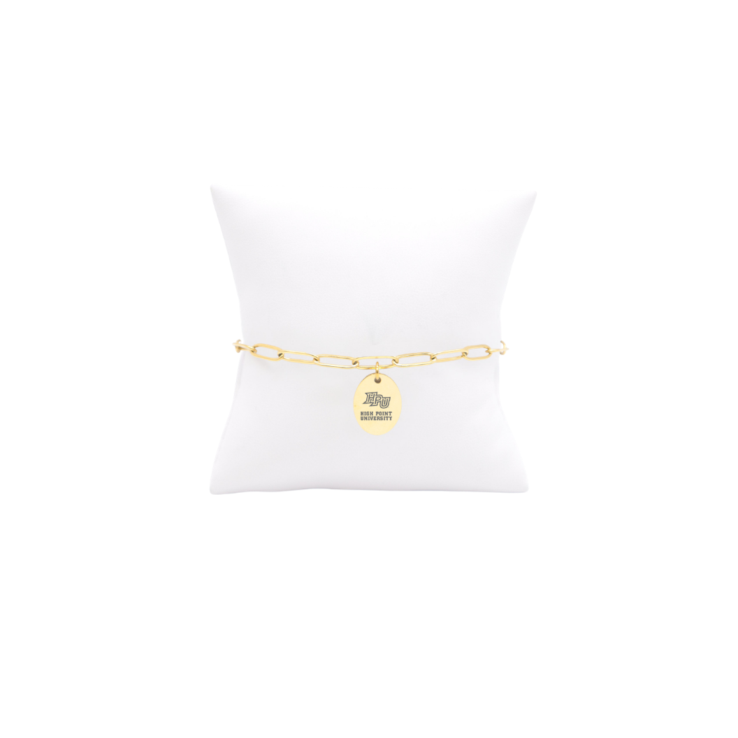 High Point University gold link storyline bracelet with small oval charm with high point university text and hpu logo on white pillow front view
