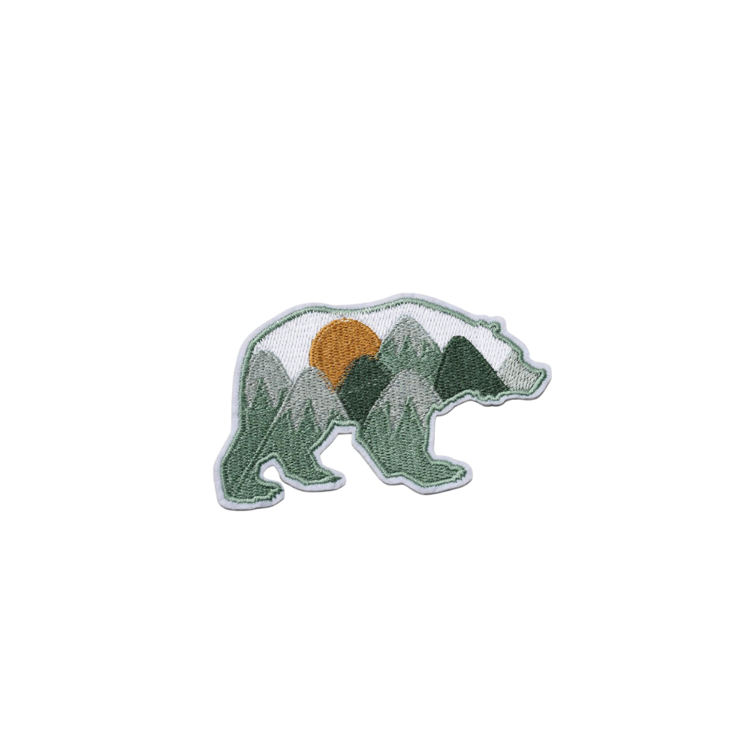 Embroidered patch of a bear with mountain design on a white background