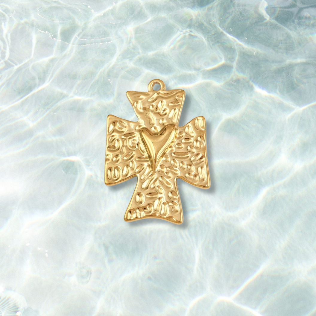 Gold cross pendant on a textured white background