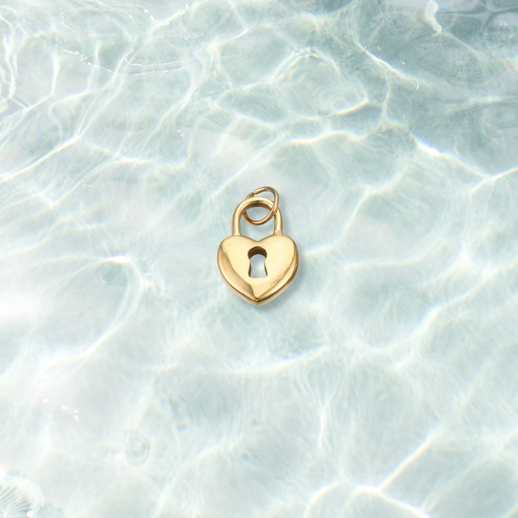 Gold Locked in Love Charm | Waterproof Stainless Steel on water background 