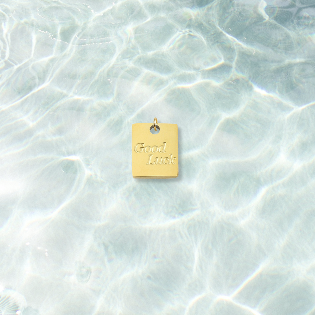 Gold Good Luck Square Charm | Waterproof Stainless Steel on water background