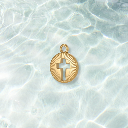 Gold Cut Out Cross Charm on a water background 