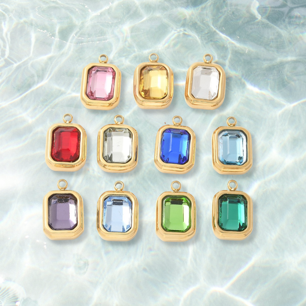 Gold Emerald Cut Assorted Gemstone Charm on water background 