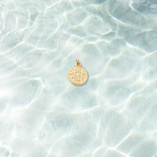 Gold Imperial Vintage Coin Charm on water background 