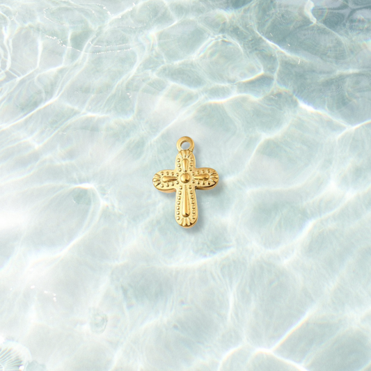 Gold Ornate Golden Faith Cross Charm on water background 