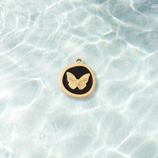 Gold Whimsical Black Butterfly Charm on water background 