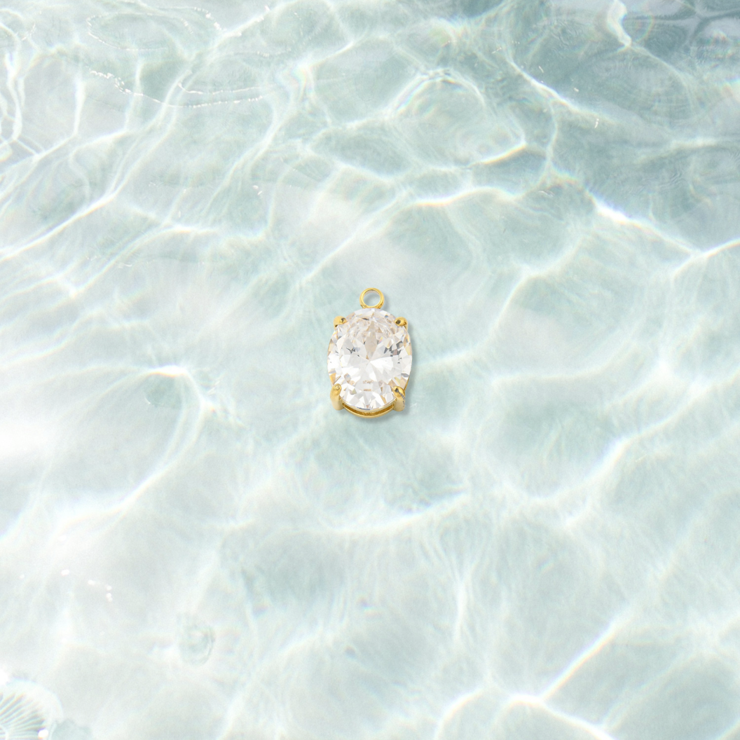 Gold Pure Brilliance Oval Cubic Zirconia Charm  on water background