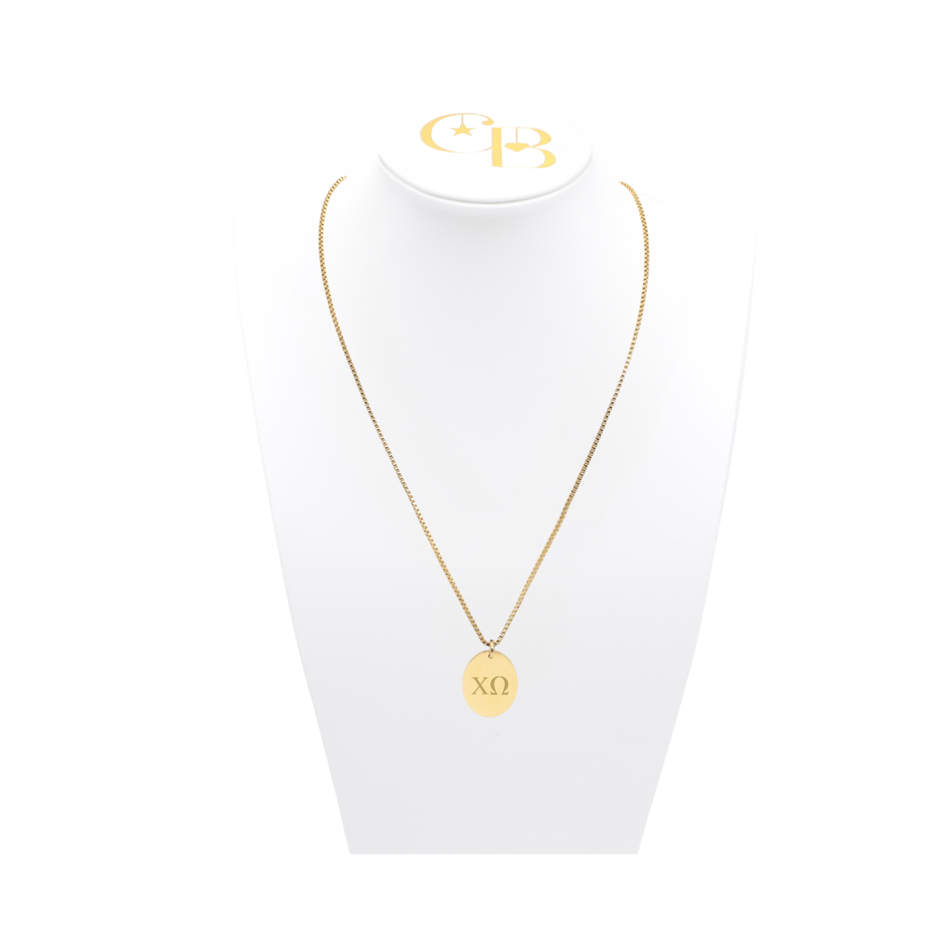 Chi Omega gold link storyline necklace with small oval charm with horizontal greek letters on white bust front view
