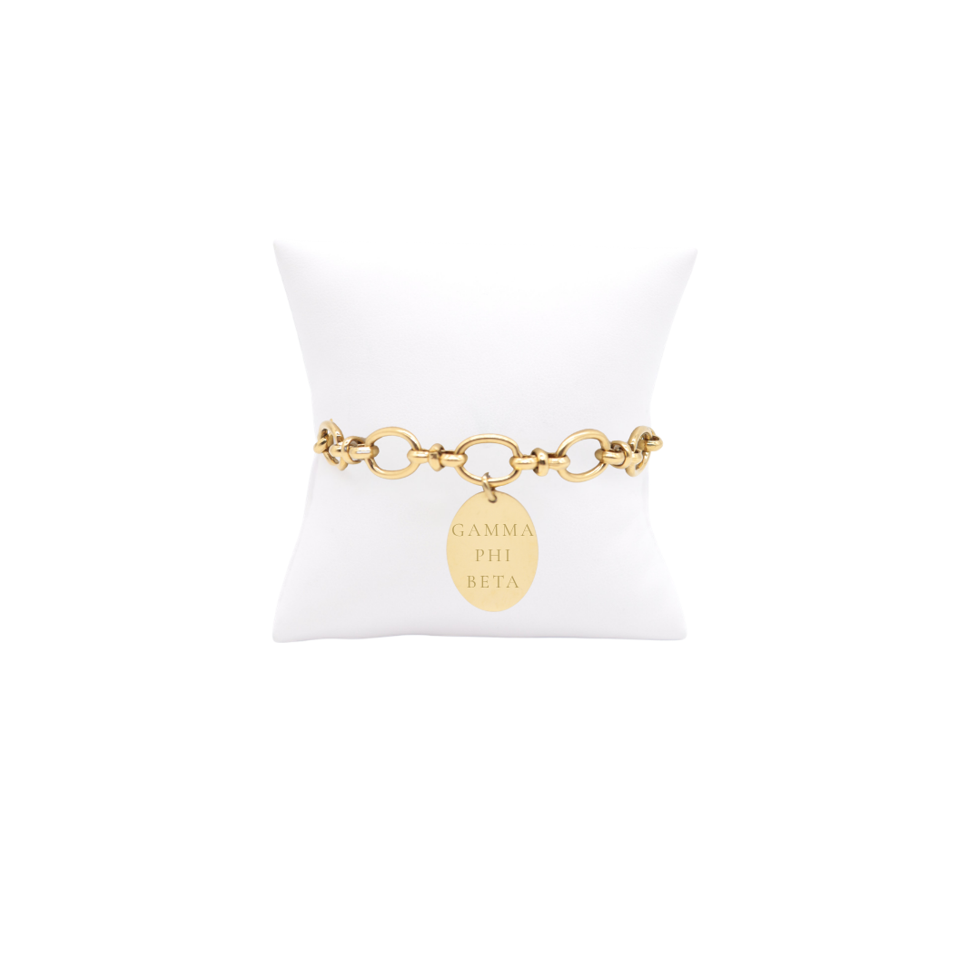 Gamma Phi Beta gold large link evermore bracelet with large oval charm displayed on white pillow front view with full sorority name