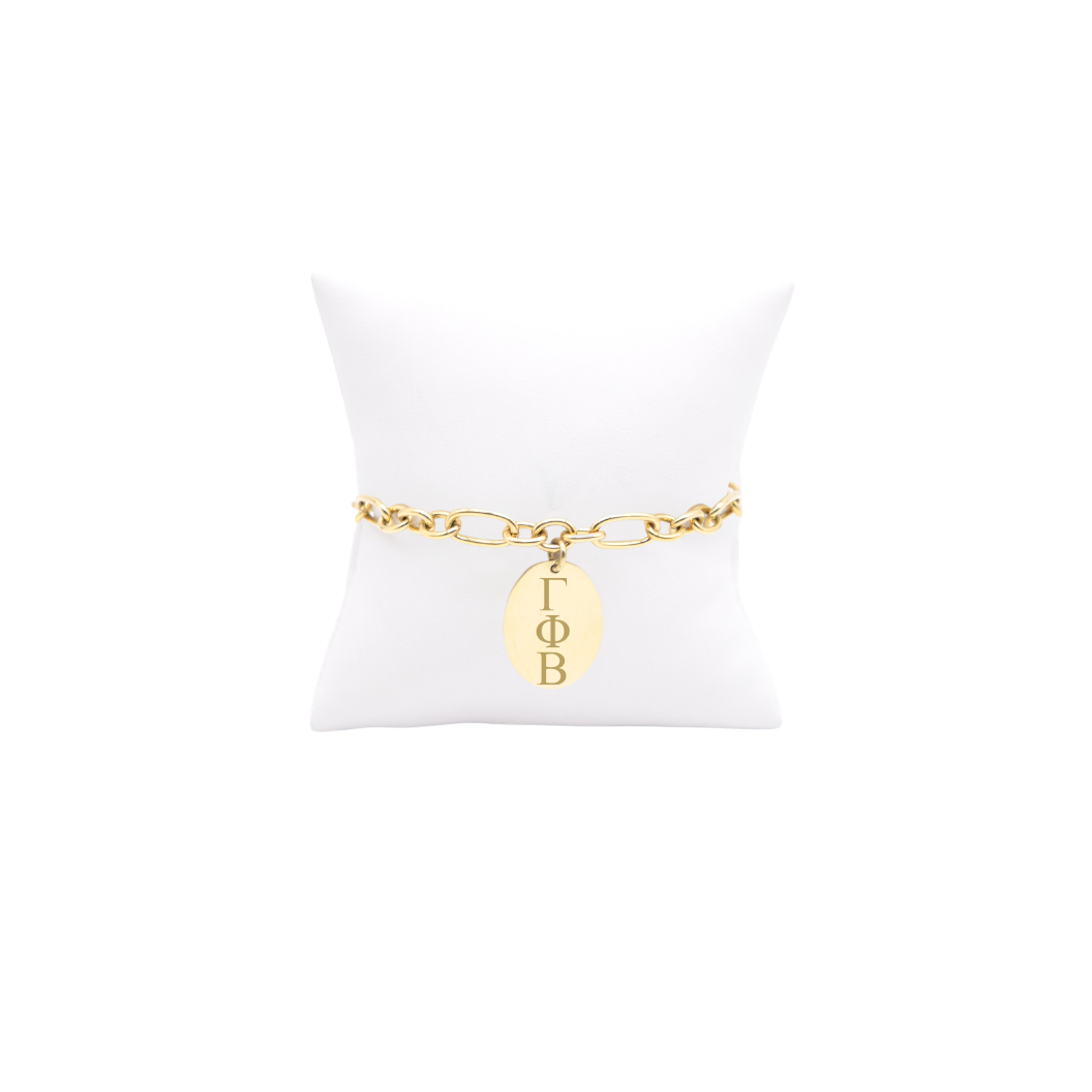 Gamma Phi Beta large link keepsake bracelet with large oval charm displayed on white pillow front view with vertical/stacked greek letters