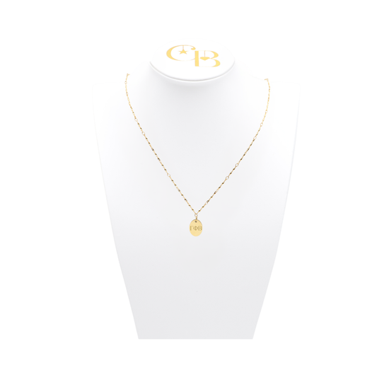 Gamma Phi Beta gold simple twist necklace with small oval charm displayed on white pillow front view with horizontal greek letters