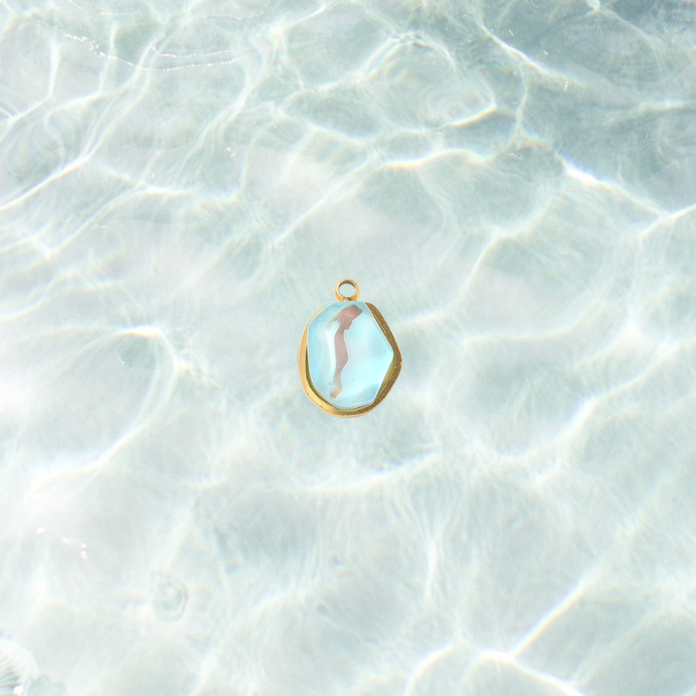 Gold aqua gemstone charm on a waterproof background