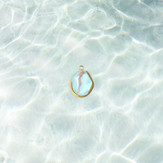 Gold aqua gemstone charm on a waterproof background