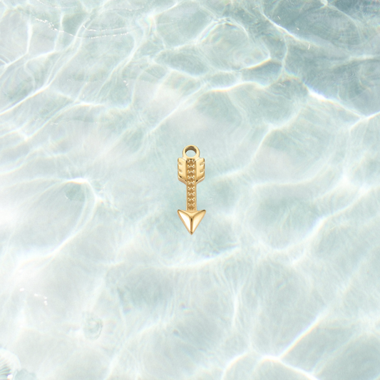 Gold crystal arrow charm on a waterproof background