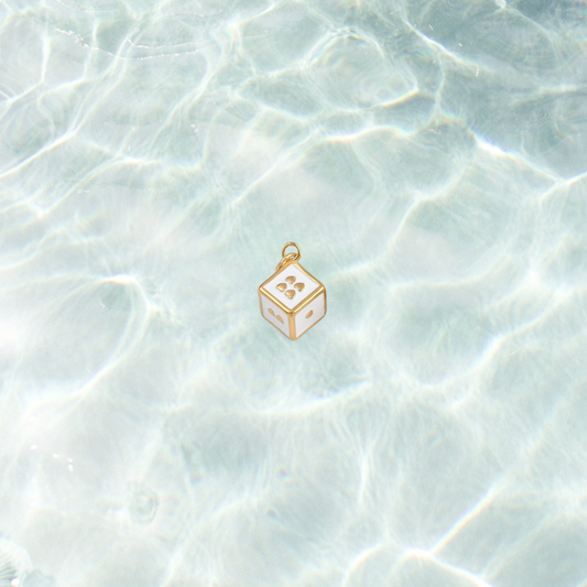 Gold lucky dice charm on waterproof background