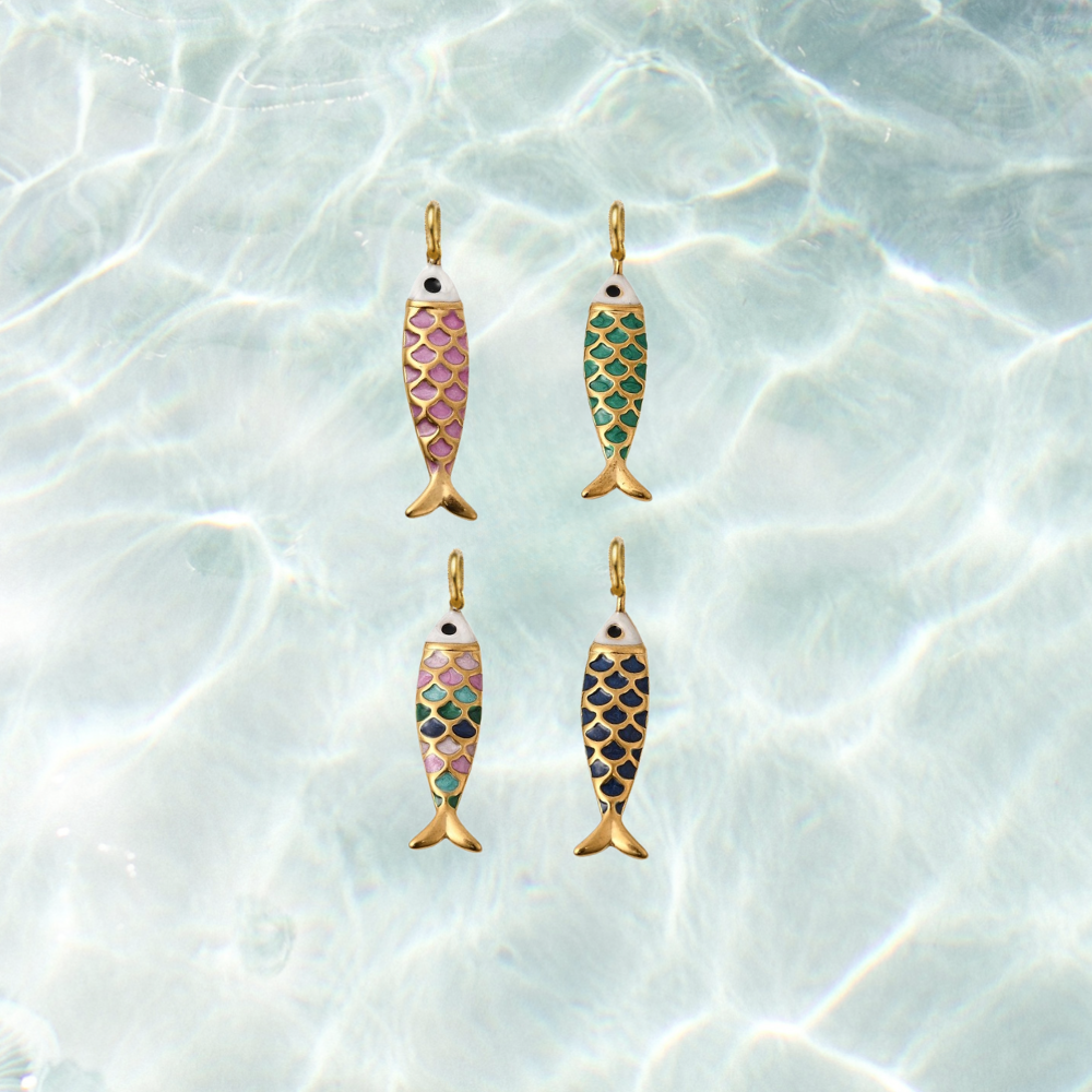 Four gold enamel fish charms featuring colorful scale patterns in dark pink, green, navy, and multicolor on a shimmering water background.