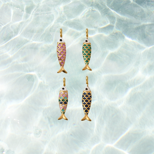 Four gold enamel fish charms featuring colorful scale patterns in dark pink, green, navy, and multicolor on a shimmering water background.