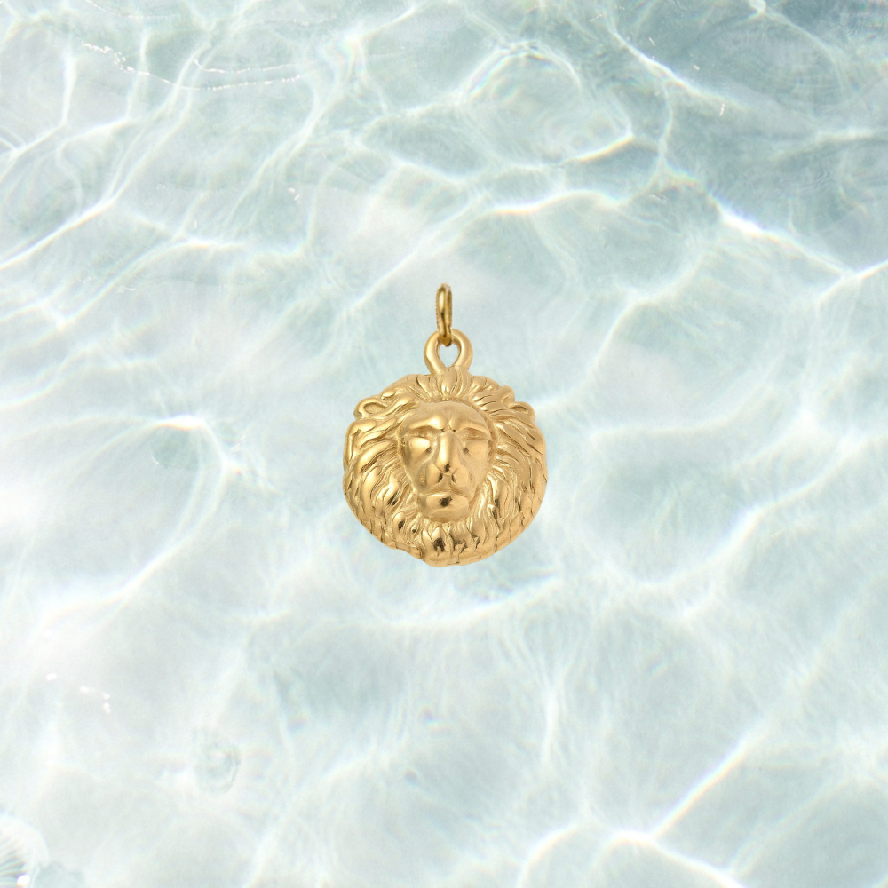 Gold Royal Lion Charm featuring a detailed lion head design with a textured mane on a shimmering water background.