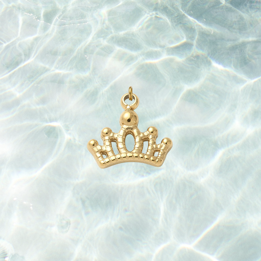 Gold tiara crown charm with an elegant openwork design on a shimmering water background.