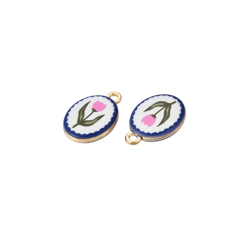 Two gold oval charms featuring pink floral illustrations with navy scalloped borders on a white background