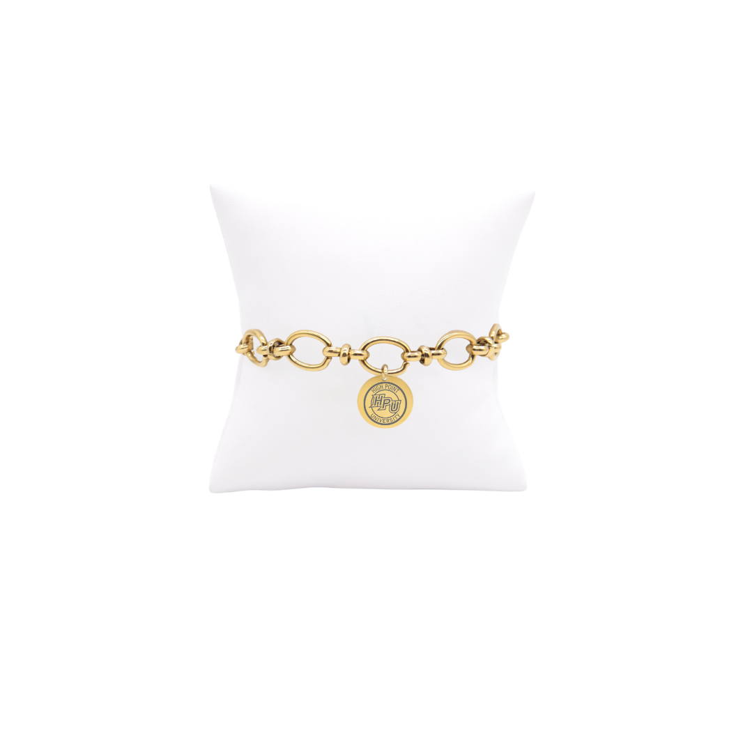 High Point University gold large link Evermore bracelet with large round charm with high point university text and hpu logo on white pillow front view
