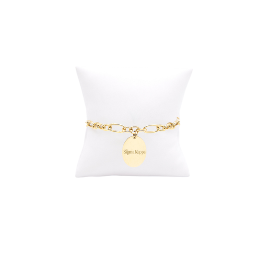 Sigma Kappa gold large link Keepsake bracelet with large oval charm with primary logo on white pillow front view