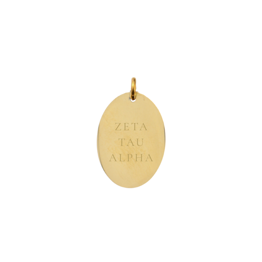 Gold pendant with 'ZETA TAU ALPHA' engraving on a white background